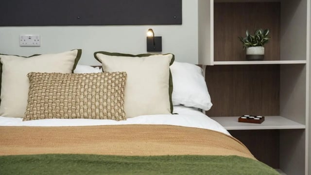 Bed with pillows blanket shelf bedroom at Broadway Studios in Glasgow Student Accommodation
