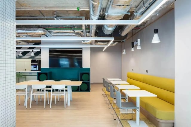 Table chairs yellow bench and coffee machine communal area at Coleman Court in Cork Student Accommodation