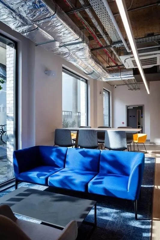 Blue sofa coffee table chairs large windows lounge area at Coleman Court in Cork Student Accommodation