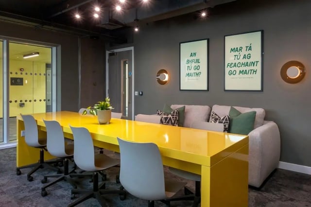Yellow table chairs sofa and wall art communal area at The Artisan in Dublin Student Accommodation