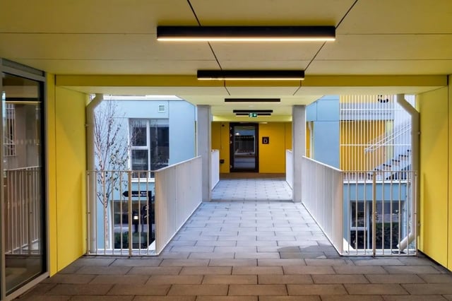 Modern hallway with yellow walls white railings exterior at The Artisan in Dublin Student Accommodation