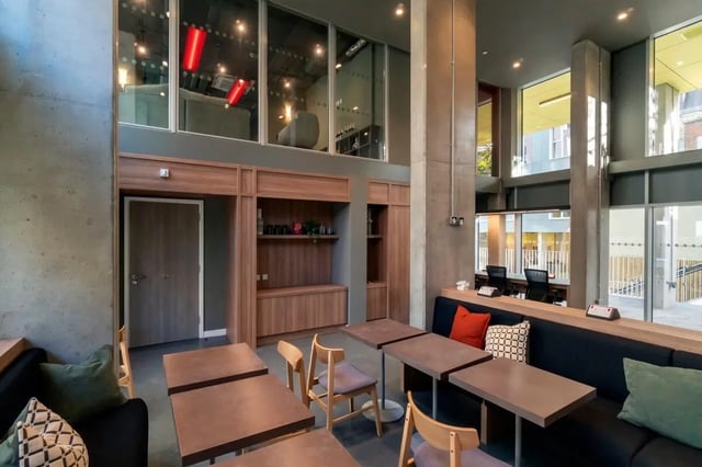 Modern communal area with tables chairs and seating lounge at The Artisan in Dublin Student Accommodation