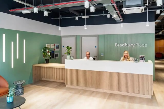 Reception desk with staff and Bradbury Place sign reception at Bradbury Place in Belfast Student Accommodation