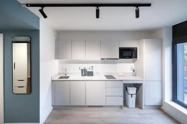 Modern kitchen with white cabinets sink kettle toaster microwave kitchen at Bradbury Place in Belfast Student Accommodation