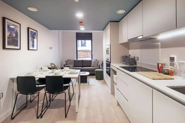 Dining table sofa and kitchen area Living room at Bradbury Place in Belfast Student Accommodation