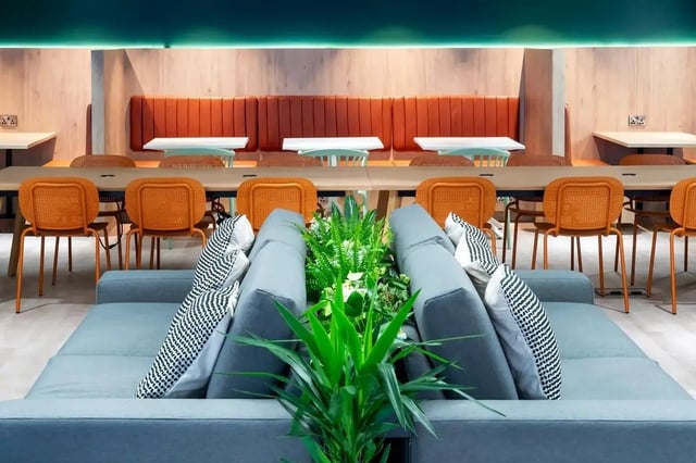 Sofa with plants and orange chairs communal area at Bradbury Place in Belfast Student Accommodation