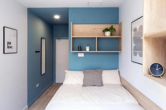 Bed with pillows artwork and shelving bedroom at Stoneybatter Place in Dublin Student Accommodation