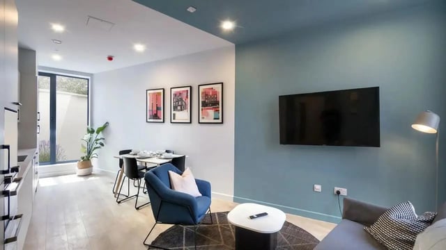 Dining table chairs armchair TV rug living room at Stoneybatter Place in Dublin Student Accommodation