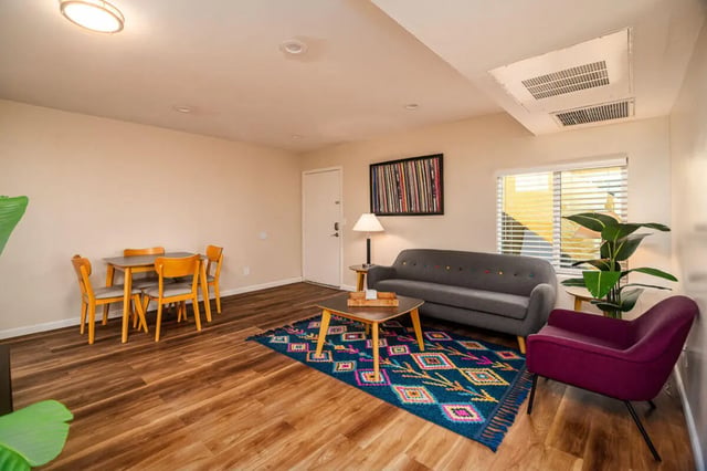 Dining table sofa colorful rug and chair living room at Union on Bellevue in Tucson Student Accommodation