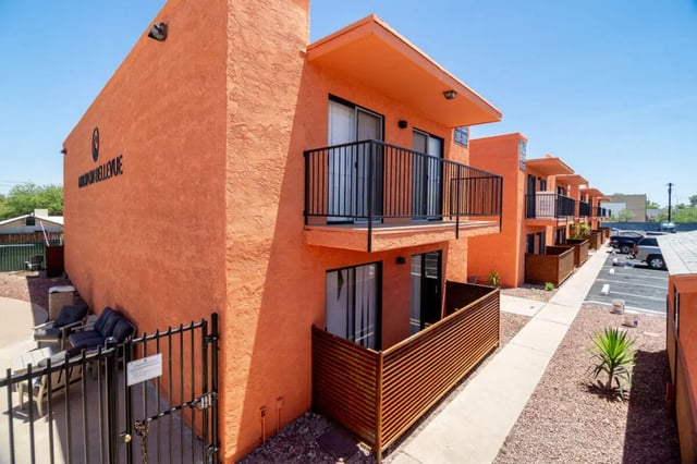 Orange apartment building with balconies and parking lot exterior at Union on Bellevue in Tucson Student Accommodation