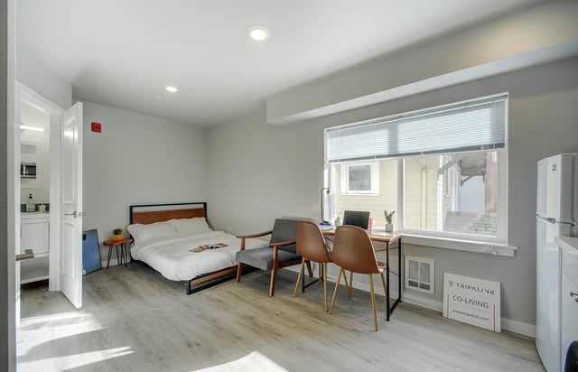 Bed desk chairs and refrigerator studio apartment at Ace Apartments in Seattle Student Accommodation