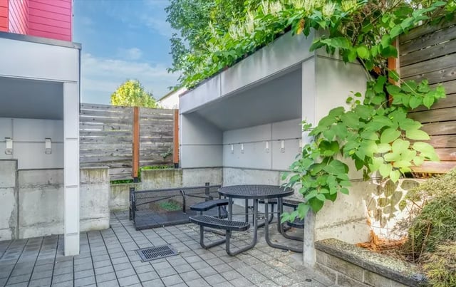 Outdoor seating area with table benches and greenery exterior at Ace Apartments in Seattle Student Accommodation