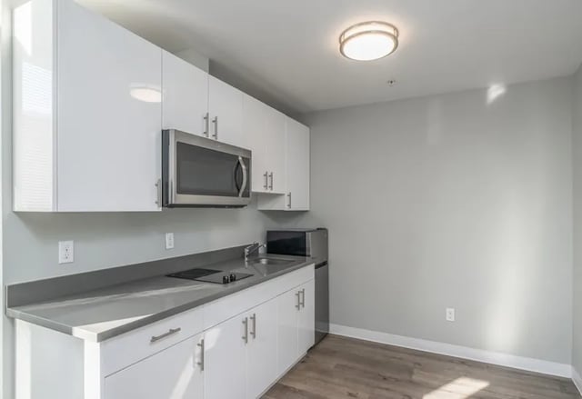 White cabinets microwave sink small fridge kitchen at Ace Apartments in Seattle Student Accommodation