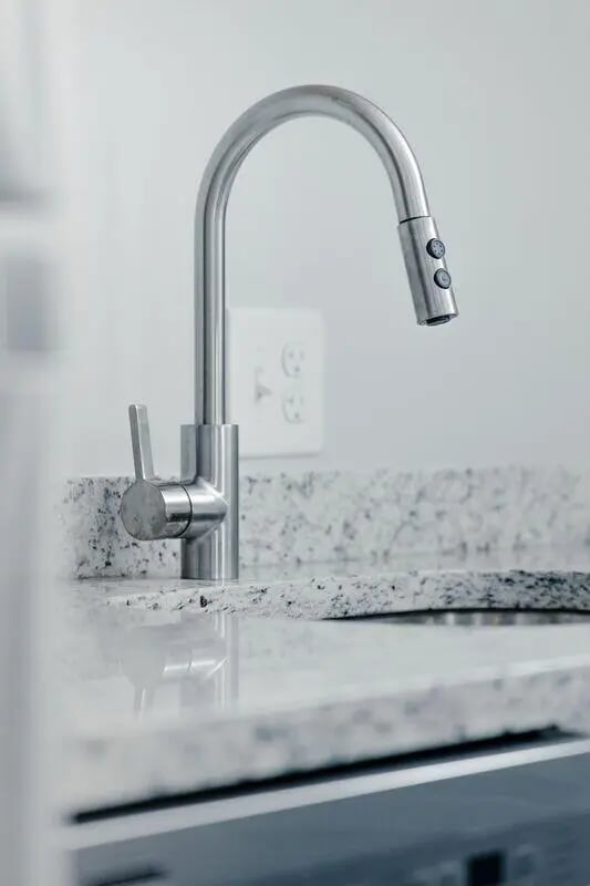 Chrome faucet on speckled countertop kitchen sink at Storrs Student Living