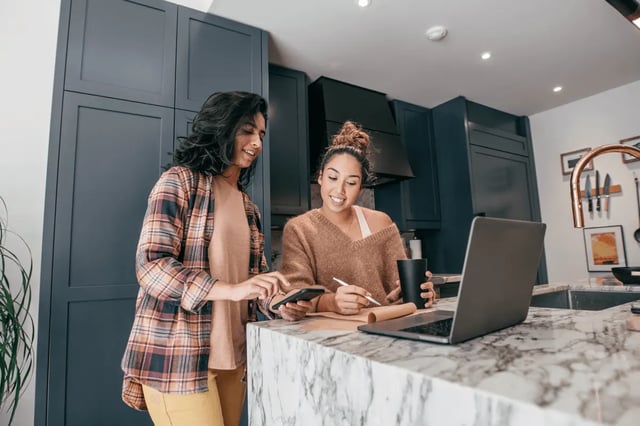 Students on laptop and phone kitchen at Storrs Student Living