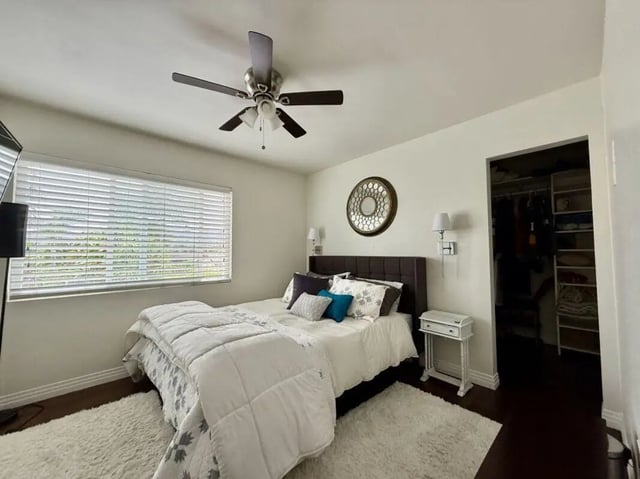 Bed with white bedding ceiling fan walk-in closet Bedroom at Universal Student Housing in Los Angeles Student Accommodation