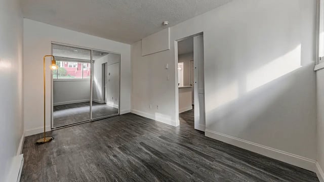 Mirrored closet door lamp and dark floor Bedroom at Victory East Lansing in East Lansing Student Accommodation