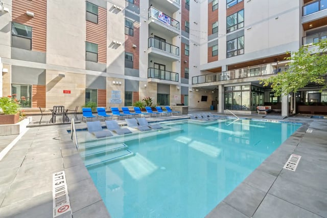 Swimming pool with lounge chairs and buildings exterior at The Villas at San Gabriel in Austin Student Accommodation
