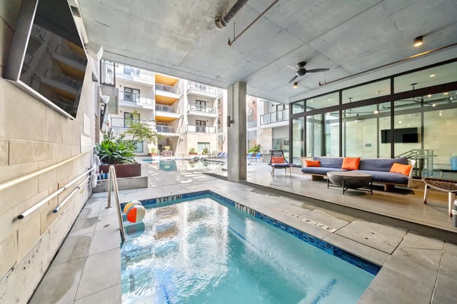 Pool with lounge seating and building exterior view living room at The Villas at San Gabriel in Austin Student Accommodation