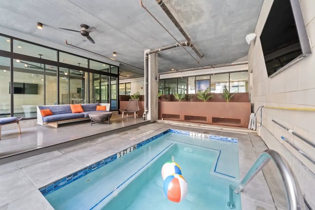 Pool with inflatable balls and lounge seating pool area at The Villas at San Gabriel in Austin Student Accommodation