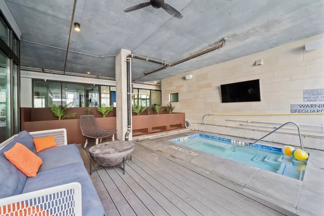 Sofa and spa with television and plants playing area at The Villas at San Gabriel in Austin Student Accommodation