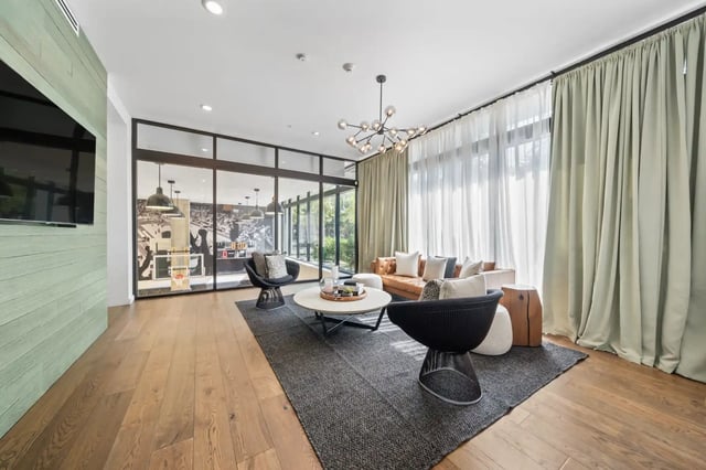 Modern living room with leather sofa and chairs at The Villas at San Gabriel in Austin Student Accommodation