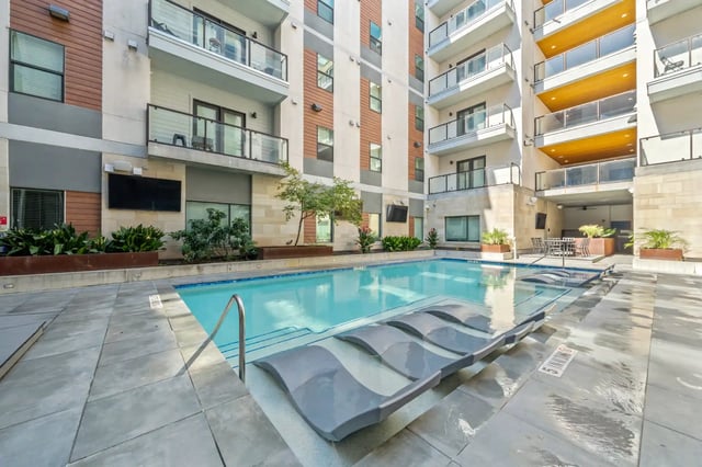 Swimming pool with loungers and building exterior pool area at The Villas at San Gabriel in Austin Student Accommodation