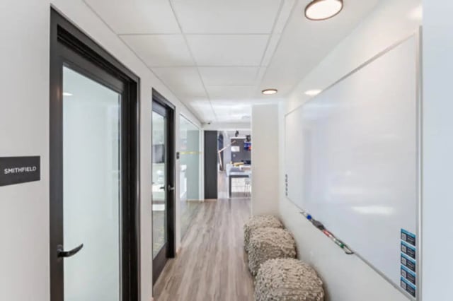 Hallway with whiteboard and poufs hallway at The Bridge on Forbes Apartments in Pittsburgh Student Accommodation