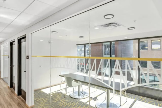 Glass meeting room with table and chairs common area at The Bridge on Forbes Apartments in Pittsburgh Student Accommodation