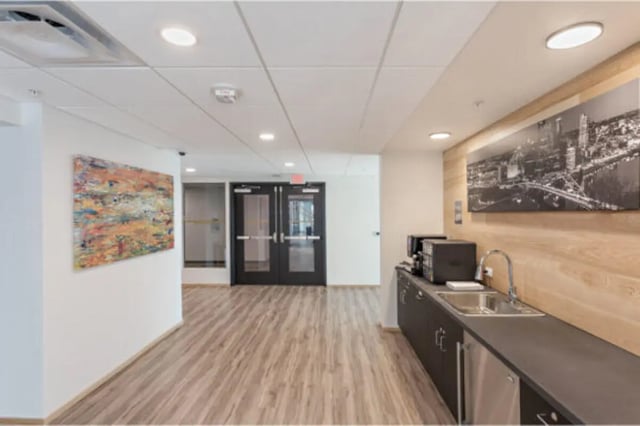 Coffee station with sink and art in hallway at The Bridge on Forbes Apartments in Pittsburgh Student Accommodation