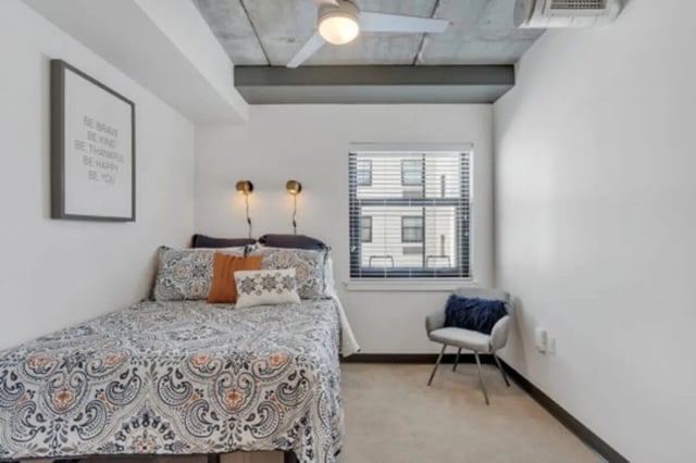 Bed with patterned bedding and chair bedroom at The Bridge on Forbes Apartments in Pittsburgh Student Accommodation