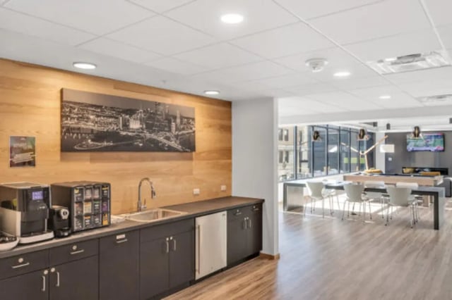 Coffee maker sink dishwasher counter with skyline picture common area at The Bridge on Forbes Apartments in Pittsburgh Student Accommodation