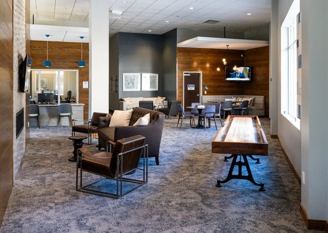 Shuffleboard table sofas chairs reception desk lounge at The Landing in West Lafayette Student Accommodation