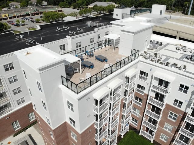 Rooftop deck with tables chairs and railing exterior at The Landing in West Lafayette Student Accommodation