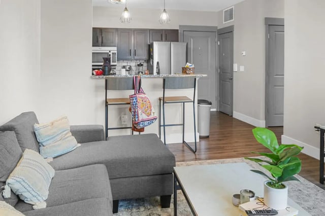 Grey sectional sofa kitchen island with stools living room at 10 North in Bloomington Student Accommodation