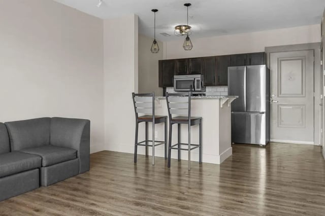 Modern gray sofa two bar stools kitchen living room at 10 North in Bloomington Student Accommodation