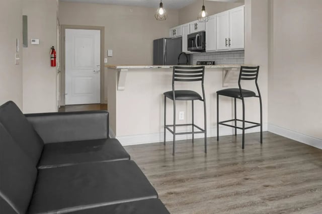 Black sofa bar stools kitchen counter interior living room at 10 North in Bloomington Student Accommodation