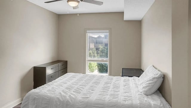 Bed dresser nightstand window ceiling fan bedroom at 10 North in Bloomington Student Accommodation