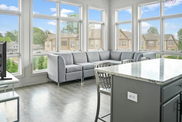 Grey sectional sofa with kitchen island living room at 10 North in Bloomington Student Accommodation