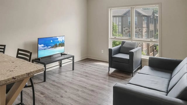 Grey sofa armchair tv on stand living room at 10 North in Bloomington Student Accommodation
