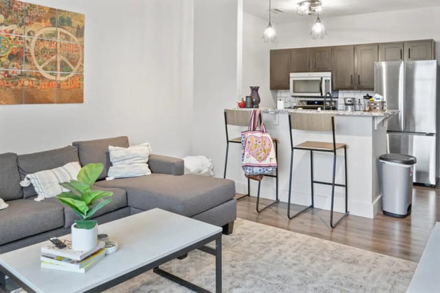 L-shaped sofa coffee table peace art kitchen living room at 10 North in Bloomington Student Accommodation