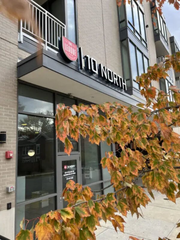 Building signage with fall leaves exterior at 10 North in Bloomington Student Accommodation