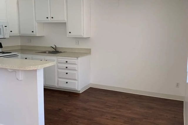 White cabinets sink microwave and counter kitchen at Aero Apartments in Davis Student Accommodation