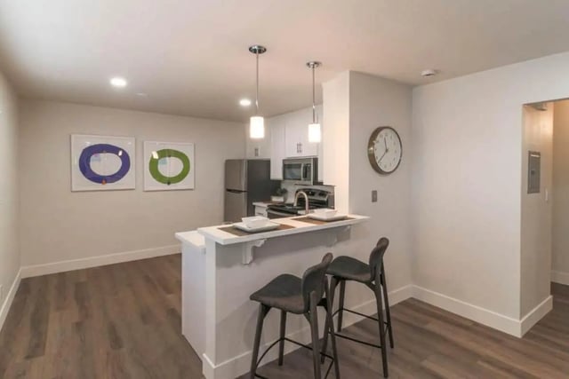 Kitchen island two bar stools artwork clock kitchen area at Aero Apartments in Davis Student Accommodation