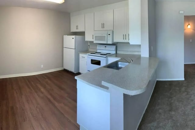 White cabinets refrigerator stove sink counter kitchen at Aero Apartments in Davis Student Accommodation