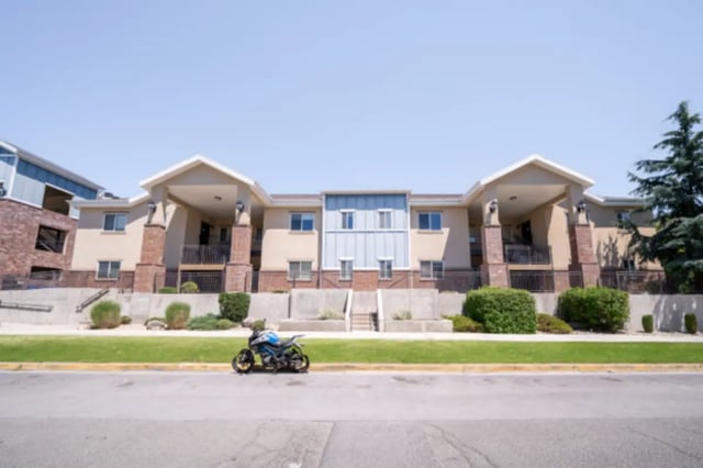 Building with blue motorcycle and trees exterior at CollegePlace Woodland in Provo Student Accommodation