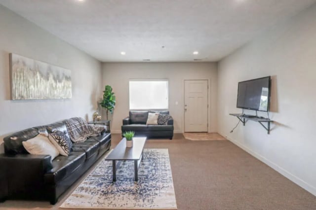 Black couches coffee table patterned rug living room at CollegePlace Woodland in Provo Student Accommodation