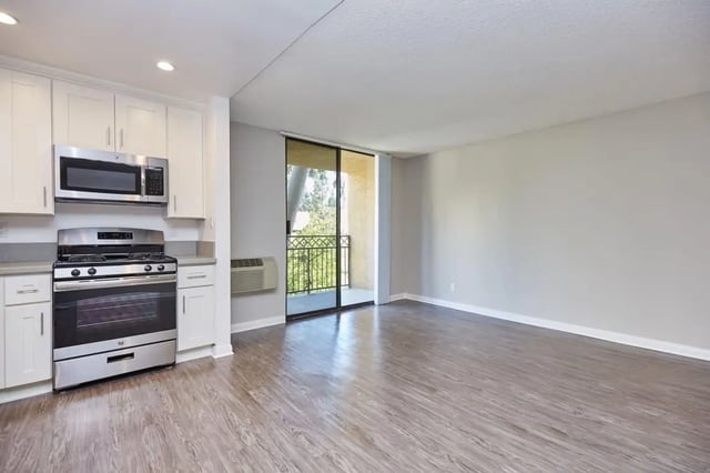 Kitchen appliances cabinets and open living space living room at Ariel Court in Los Angeles Student Accommodation