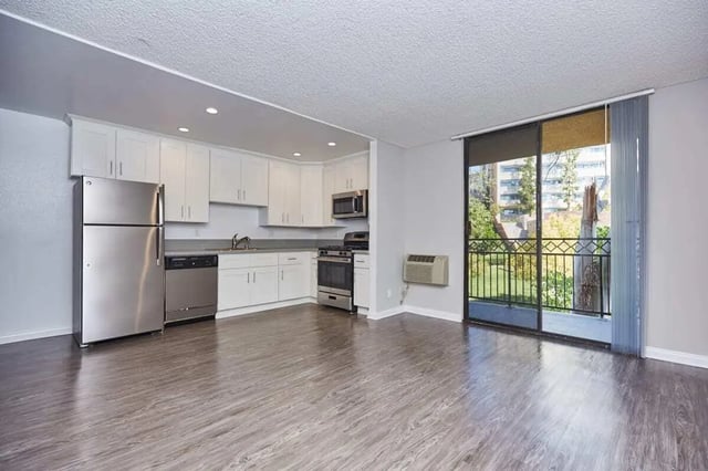 Stainless steel refrigerator dishwasher stove kitchen cabinets living area at Ariel Court in Los Angeles Student Accommodation