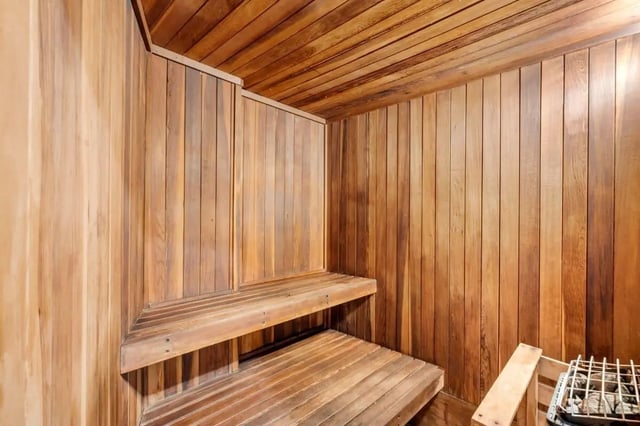 Wooden sauna with tiered benches and heater sauna at Ariel Court in Los Angeles Student Accommodation